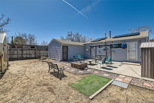 7940 Pontiac St, Commerce City, CO 80022 - rear view of property with a fenced backyard, a fire pit, solar panels, a patio area, and stucco siding