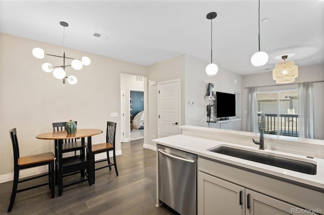 1831 S Dunkirk St Unit 103, Aurora, CO 80017 - kitchen with stainless steel dishwasher, dark wood-style flooring, a chandelier, light countertops, and pendant lighting