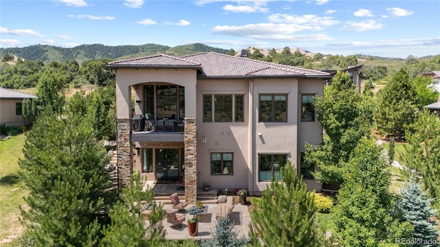 8000 Raphael Ln, Littleton, CO 80125 - rear view of property with a balcony, stucco siding, a patio area, a mountain view, and a tile roof