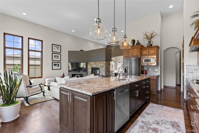 8000 Raphael Ln, Littleton, CO 80125 - kitchen with stainless steel appliances, a towering ceiling, dark wood-style flooring, open floor plan, and decorative backsplash