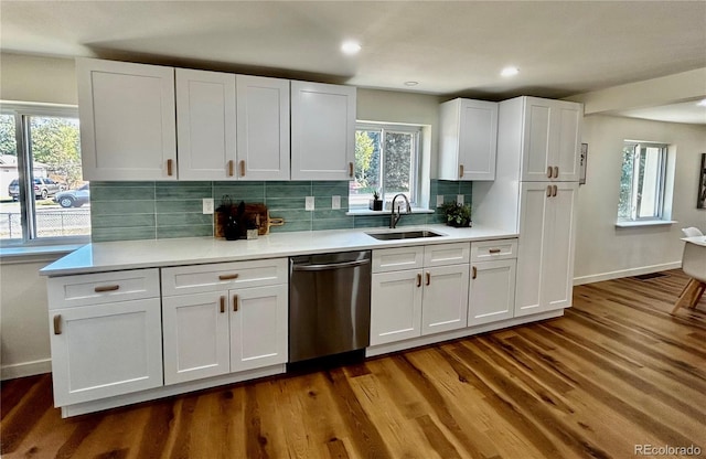 kitchen with tasteful backsplash, white cabinets, dark wood-type flooring, plenty of natural light, and dishwasher