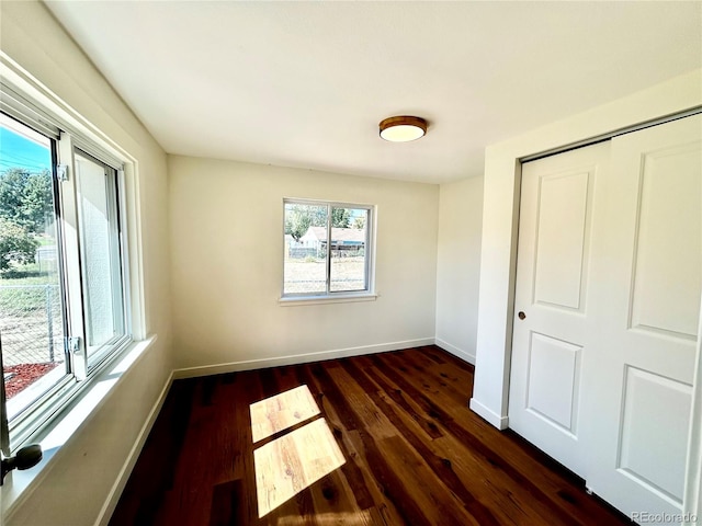 unfurnished bedroom with a closet and dark hardwood / wood-style flooring