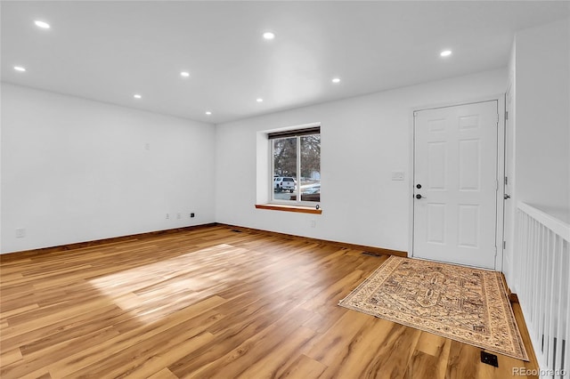 foyer entrance featuring light wood-type flooring, baseboards, visible vents, and recessed lighting