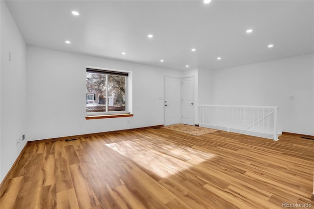 unfurnished room featuring baseboards, light wood finished floors, visible vents, and recessed lighting