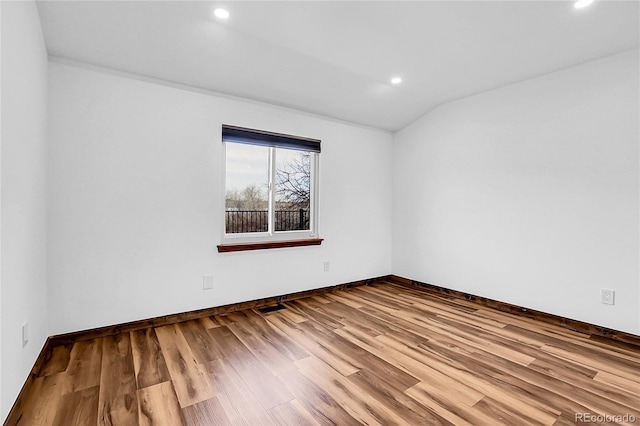 unfurnished room with lofted ceiling, wood finished floors, visible vents, and recessed lighting