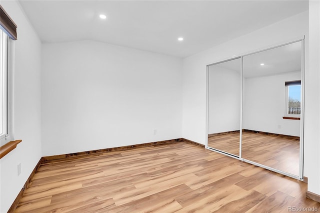 unfurnished bedroom with light wood finished floors, baseboards, a closet, and recessed lighting