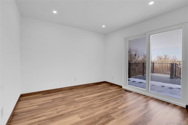 spare room with light wood-style floors, baseboards, visible vents, and recessed lighting