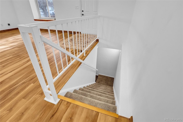 stairs with baseboards and wood finished floors