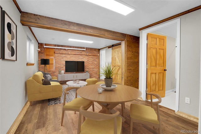 living area featuring wood finished floors, beam ceiling, and baseboards