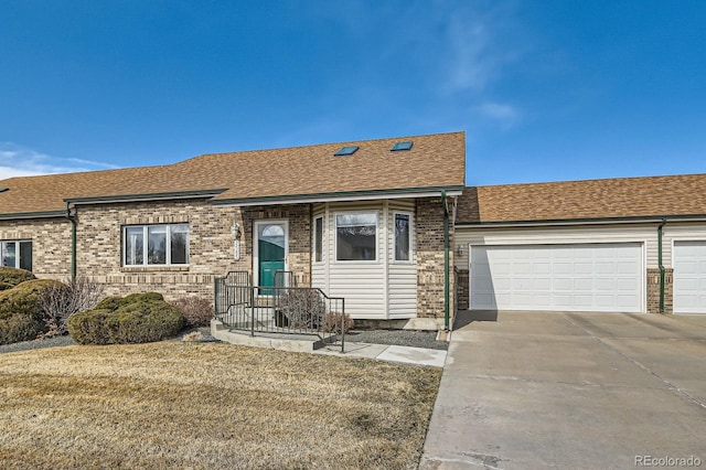 ranch-style house with driveway, brick siding, roof with shingles, and an attached garage