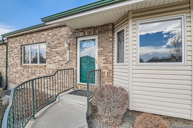 doorway to property featuring brick siding