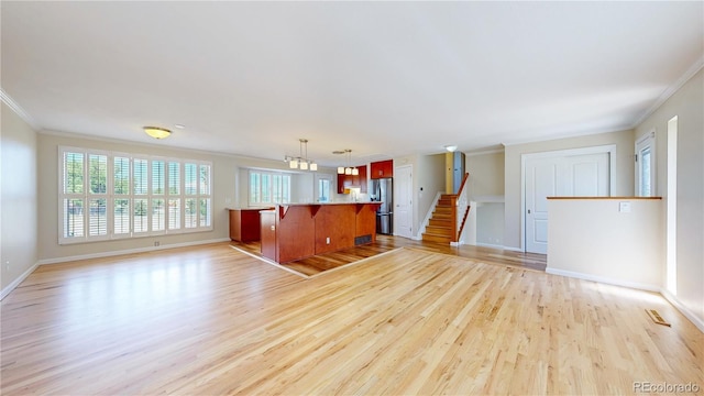 9629 Yukon Ct, Westminster, CO 80021 - unfurnished living room featuring crown molding, light wood finished floors, and stairway