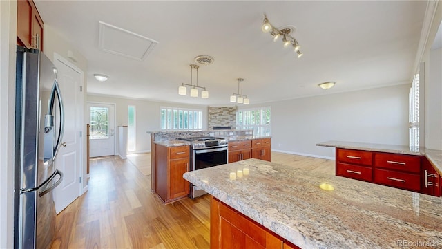 9629 Yukon Ct, Westminster, CO 80021 - kitchen with appliances with stainless steel finishes, light wood finished floors, a kitchen island, hanging light fixtures, and light stone countertops
