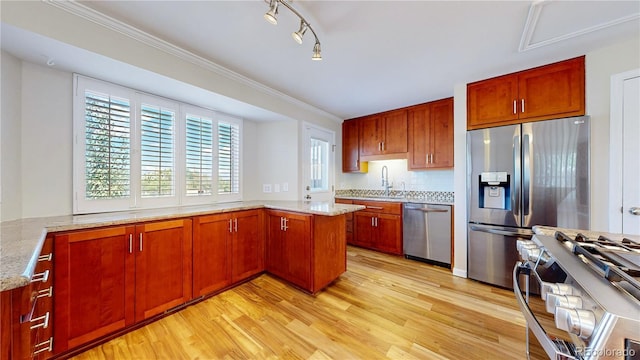 9629 Yukon Ct, Westminster, CO 80021 - kitchen with stainless steel appliances, a peninsula, light wood-style floors, plenty of natural light, and crown molding