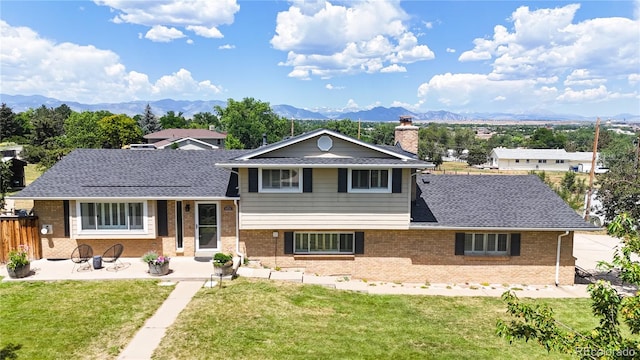 9629 Yukon Ct, Westminster, CO 80021 - split level home featuring brick siding, a mountain view, a patio area, and a chimney