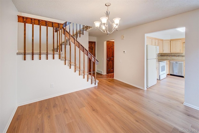 2713 W Long Dr Unit C, Littleton, CO 80120 - unfurnished dining area featuring a chandelier, light wood-style floors, and stairway