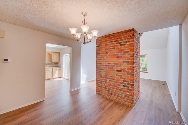 2713 W Long Dr Unit C, Littleton, CO 80120 - empty room featuring wood finished floors, a chandelier, and a textured ceiling