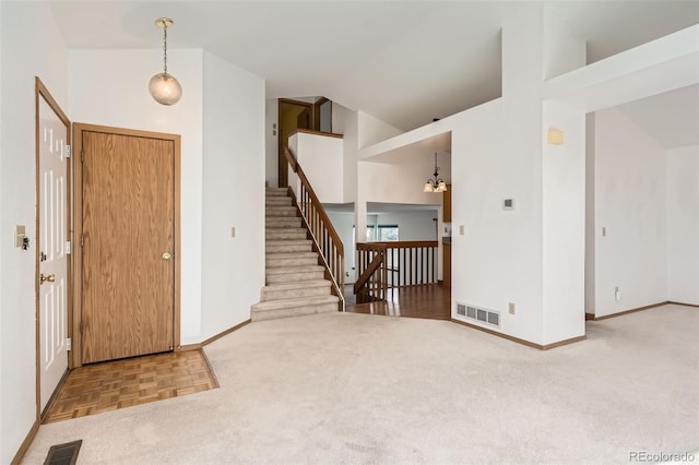 carpeted foyer entrance with a high ceiling