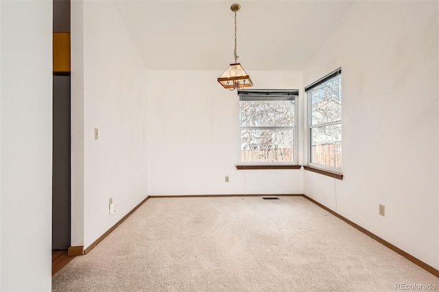 carpeted spare room featuring lofted ceiling