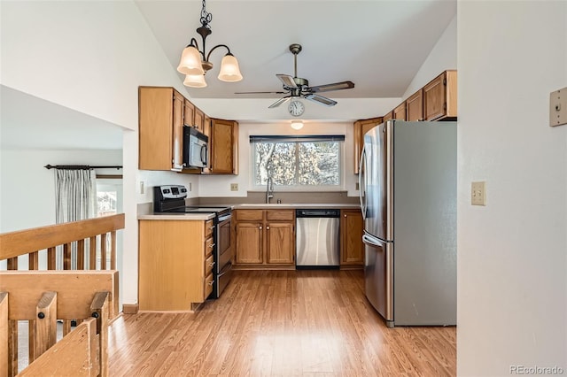 kitchen with vaulted ceiling, appliances with stainless steel finishes, pendant lighting, ceiling fan, and light hardwood / wood-style flooring