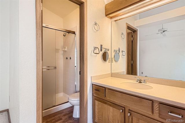 bathroom with vanity, toilet, a shower with door, and hardwood / wood-style floors