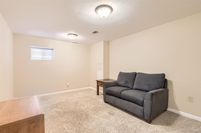 sitting room with a textured ceiling and carpet flooring