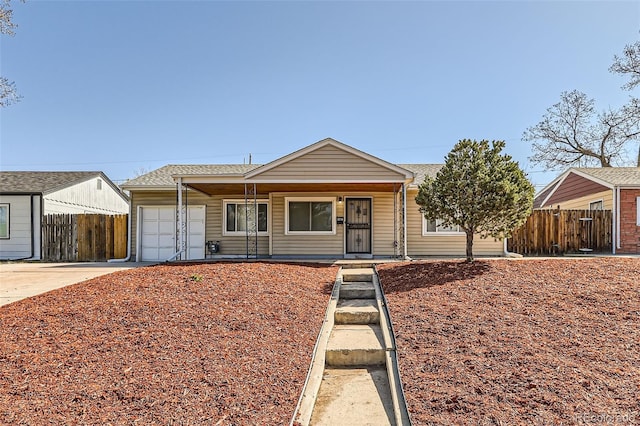 3016 S Grape Way, Denver, CO 80222 - view of front of house with an attached garage, fence, covered porch, and driveway