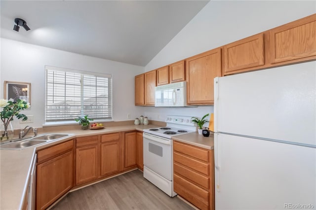 kitchen featuring white appliances, lofted ceiling, a sink, light countertops, and light wood-style floors