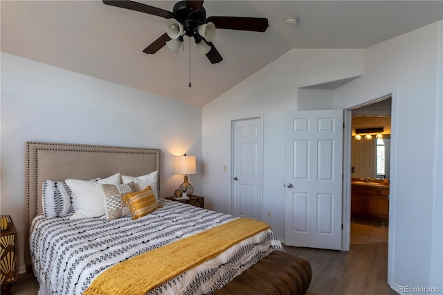 bedroom featuring a sink, vaulted ceiling, wood finished floors, and ceiling fan