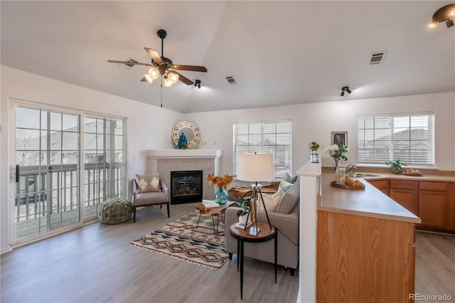 3260 E 103rd Pl Unit 912, Thornton, CO 80229 - living room featuring ceiling fan, light wood-style flooring, a glass covered fireplace, and vaulted ceiling