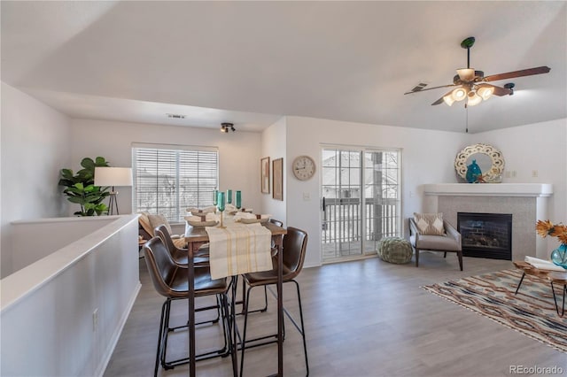 3260 E 103rd Pl Unit 912, Thornton, CO 80229 - dining room featuring wood finished floors, a ceiling fan, and a glass covered fireplace