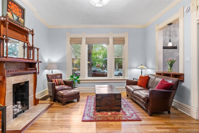 848 S Emerson St, Denver, CO 80209 - living area with wood finished floors, a tiled fireplace, crown molding, baseboards, and a textured ceiling