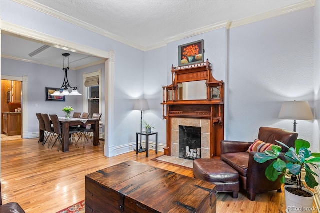 848 S Emerson St, Denver, CO 80209 - living room featuring light wood finished floors, crown molding, baseboards, and a tile fireplace