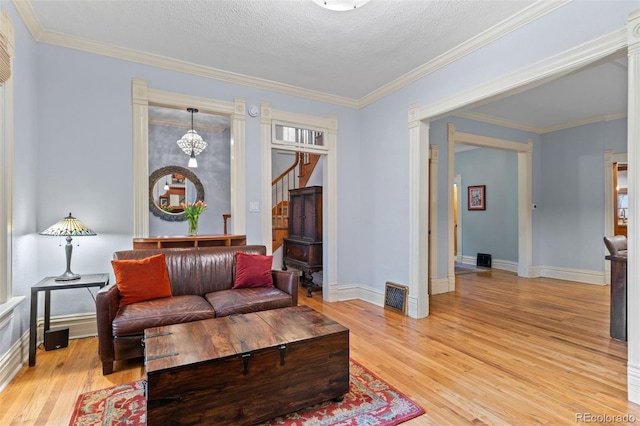 848 S Emerson St, Denver, CO 80209 - living room featuring light wood-style floors, baseboards, stairs, crown molding, and a textured ceiling