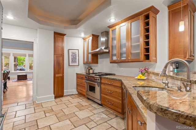 848 S Emerson St, Denver, CO 80209 - kitchen with wall chimney exhaust hood, stainless steel stove, brown cabinetry, baseboards, and a sink