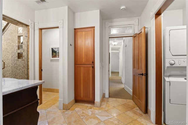 848 S Emerson St, Denver, CO 80209 - bathroom with stacked washer and clothes dryer, vanity, baseboards, and tiled shower