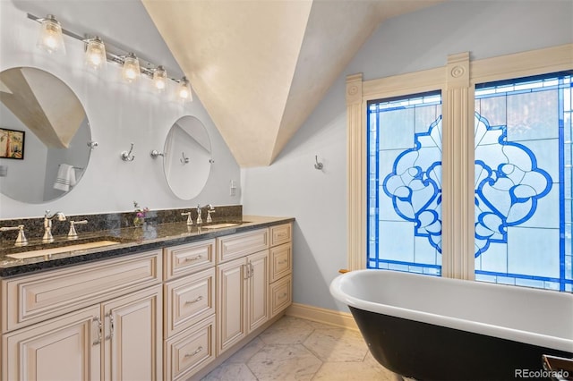 848 S Emerson St, Denver, CO 80209 - bathroom with double vanity, lofted ceiling, a freestanding bath, marble look tiles, and baseboards