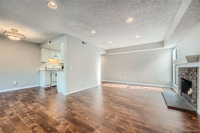 unfurnished living room featuring dark hardwood / wood-style flooring, a textured ceiling, and a fireplace