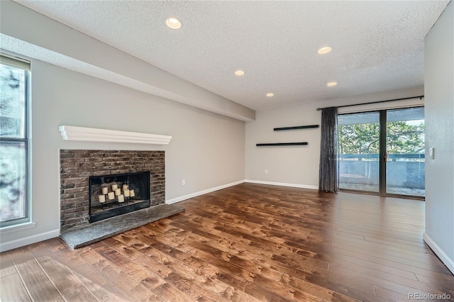 unfurnished living room with a fireplace, hardwood / wood-style floors, and a textured ceiling