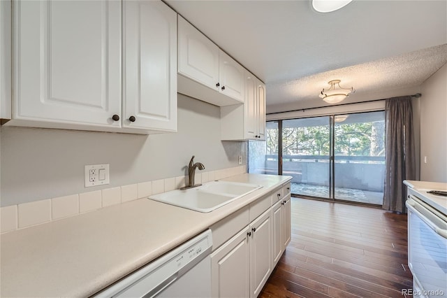 kitchen featuring a textured ceiling, sink, white appliances, white cabinetry, and dark hardwood / wood-style floors