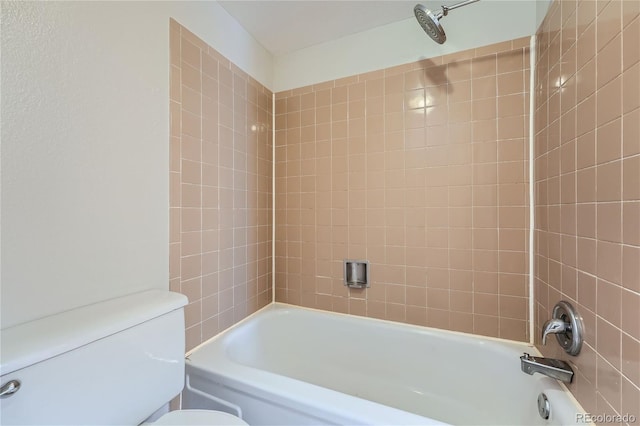 bathroom featuring tiled shower / bath combo and toilet