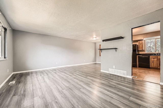 16623 E Asbury Pl, Aurora, CO 80013 - unfurnished living room featuring a textured ceiling and wood finished floors