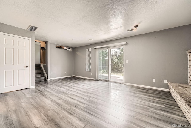 16623 E Asbury Pl, Aurora, CO 80013 - unfurnished living room featuring a textured ceiling, wood finished floors, and stairway