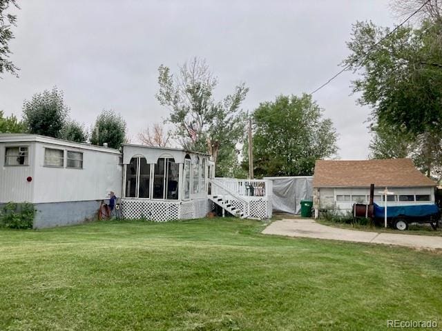 rear view of house with a yard and a sunroom