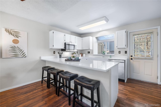 kitchen with light countertops, appliances with stainless steel finishes, a breakfast bar, and a sink