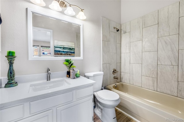 bathroom with vanity, toilet,  shower combination, and wood finished floors