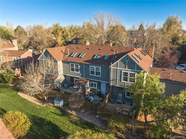back of house featuring a yard, a deck, a chimney, and a residential view