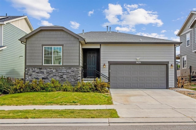 9674 Truckee St, Commerce City, CO 80022 - view of front of home featuring an attached garage, driveway, a front yard, and stone siding