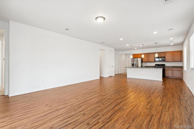 9674 Truckee St, Commerce City, CO 80022 - unfurnished living room featuring visible vents, recessed lighting, a sink, and wood finished floors
