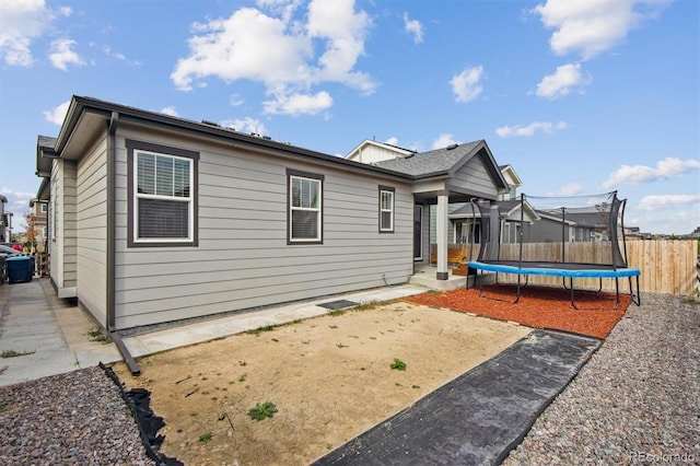 9674 Truckee St, Commerce City, CO 80022 - rear view of property with a trampoline, a patio area, and fence
